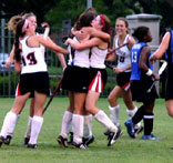 A team celebrates a victory, embracing in a joyous huddle.